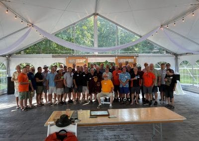 Group photo of guests at Lupines & Lace wedding venue under a large tent.