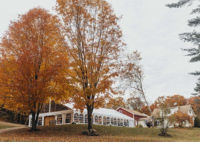 Wedding venue with autumn trees and elegant tent setup.